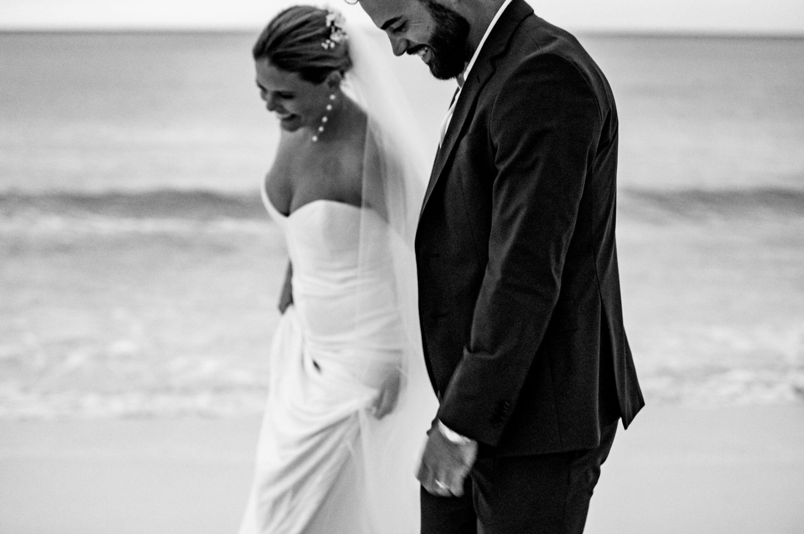 Bride and groom walking holding hands and smiling on the beach in Nassau Bahamas